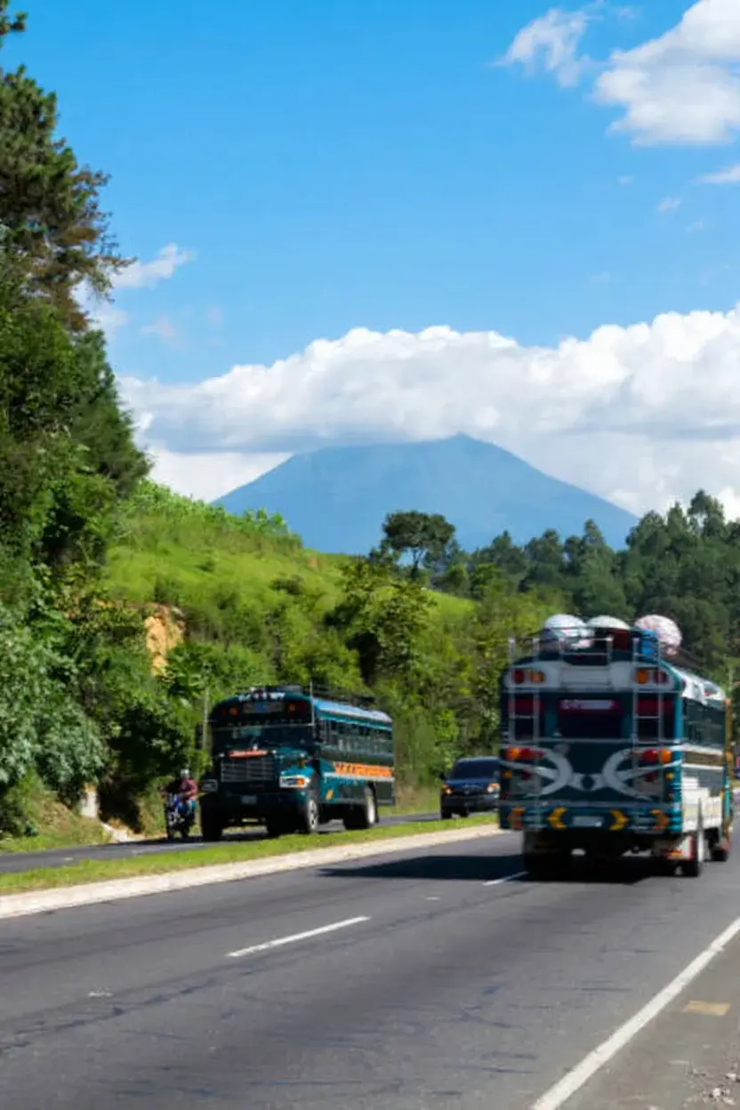 Transporte público en Guatemala mostrando un chicken bus colorido en una calle vibrante.